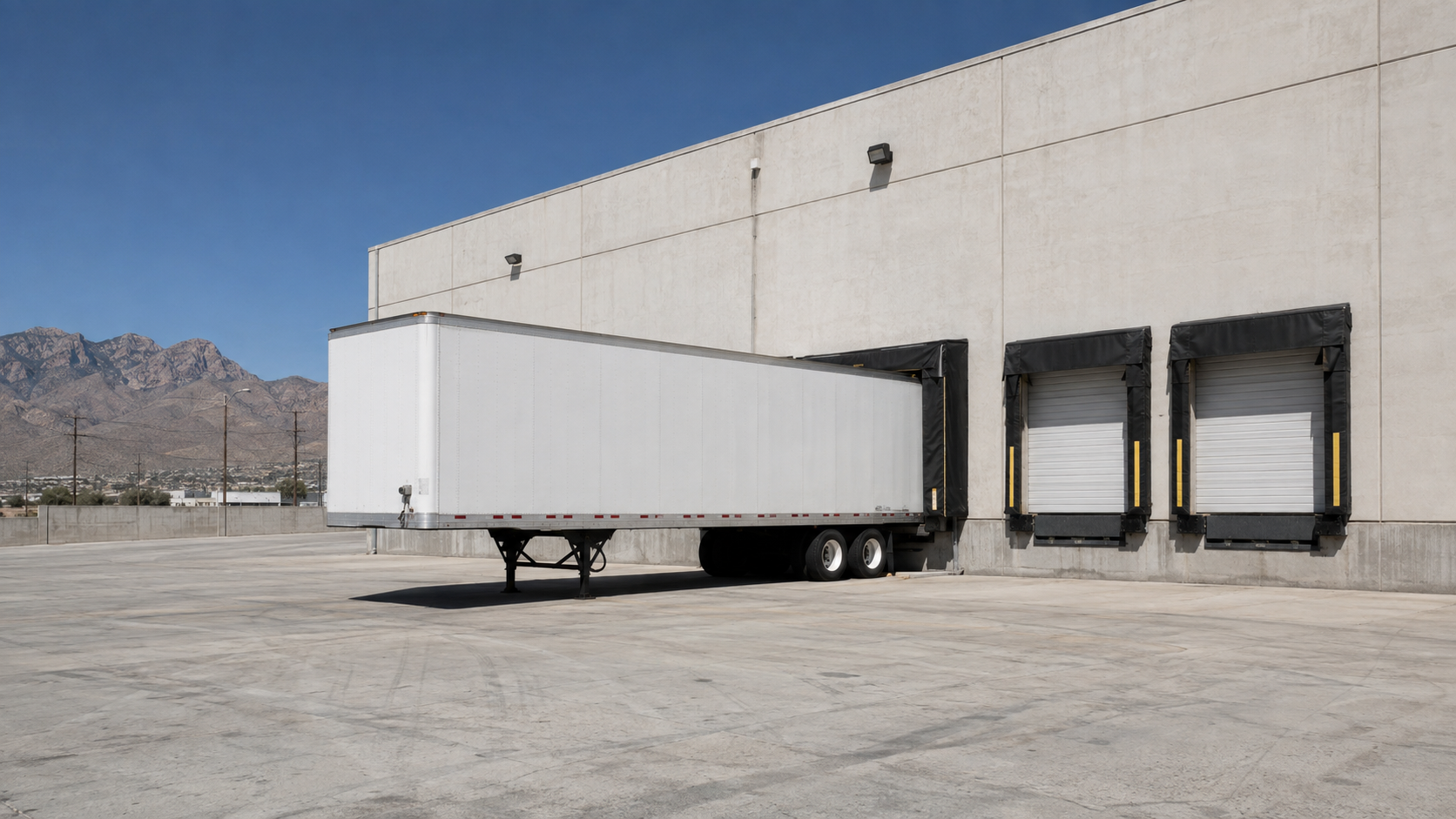 Generic trailer positioned at a warehouse dock in an El Paso industrial setting